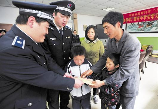 　洪山區城管隊員將捐款送至徐軍勝（右一）及小安康（右二）手中