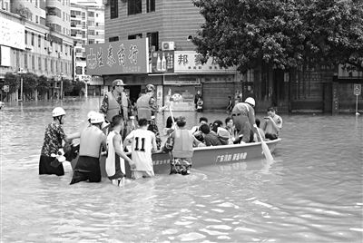 18日，廣東省清遠市陽山縣縣城,消防官兵合力推動沖鋒舟，轉移被困學生。新華社發