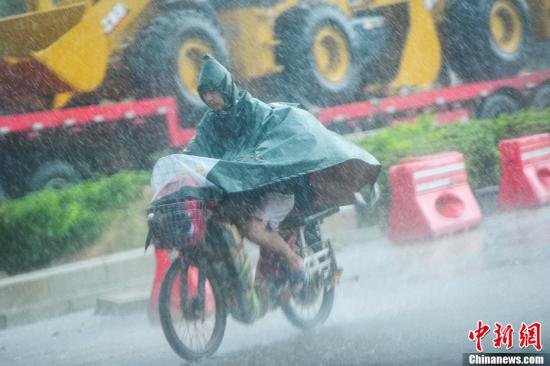 圖為南寧市民冒雨出行。中新社發 馮抒敏 攝