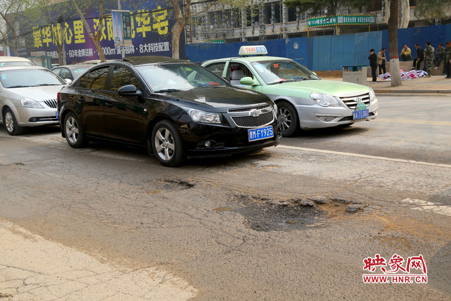 南陽路上汽車繞坑而行