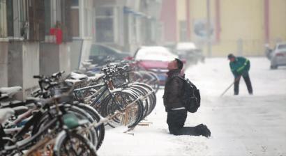 小伙子跪在樓前，一直抬頭看著樓上。 孫立國/攝