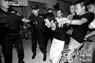 犯罪嫌疑人韓牙某圍著圍裙在廚房內拉面，被民警抓獲 本報記者 鄧小衛 攝