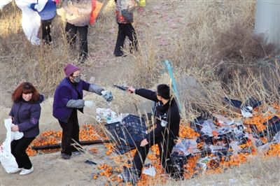 1月4日，連霍高速蘭州市榆中縣和平鎮段，一名警察舉著槍驅散哄搶橘子的村民。圖/CFP