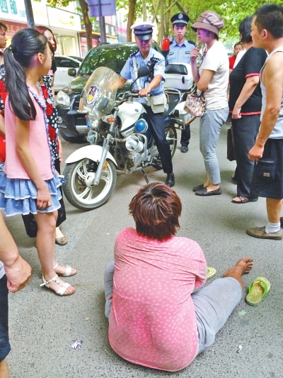 在鄭州優勝南路東三街交叉口向東100米處，一名短發中年女子平躺在路南快車道上，身旁還有一只掉落的拖鞋