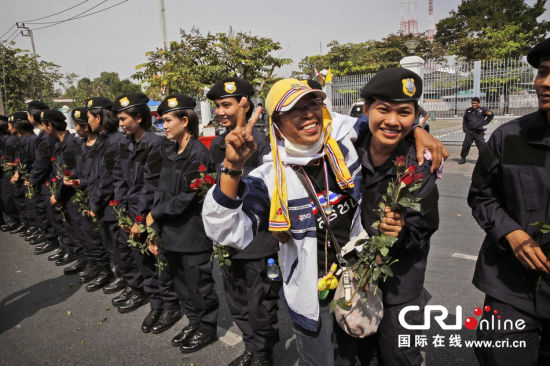 2013年12月03日,曼谷總理府與曼谷警署允許反政府示威民眾進(jìn)入,雙方進(jìn)入暫時“停戰(zhàn)”狀態(tài)迎接泰王生日。曼谷警察總署,女警們手持鮮花送給反政府示威民眾。圖片來源:Manish Swarup/東方IC