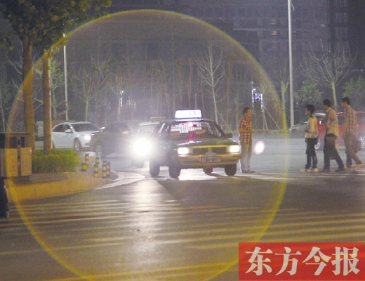 昨晚，鄭州火車東站，一些出租車停靠在路邊，見到行人不時主動搭訕 東方今報暗訪組 攝