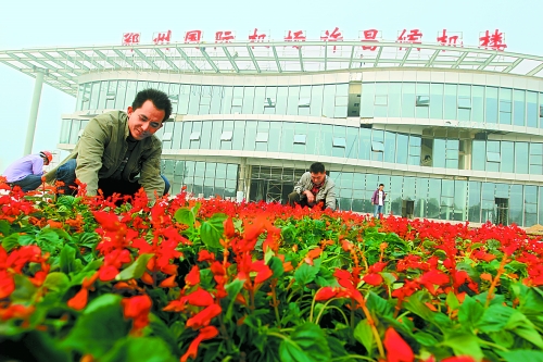 9月23日，工人們正在鄭州國際機場許昌候機樓前擺放鮮花。