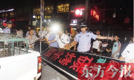 7月8日晚，鄭州市商城路一家占道經(jīng)營的攤販招牌被執(zhí)法隊員“登記保存”