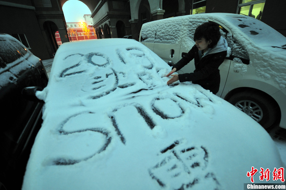 11月18日，行人在車輛的積雪上涂鴉。