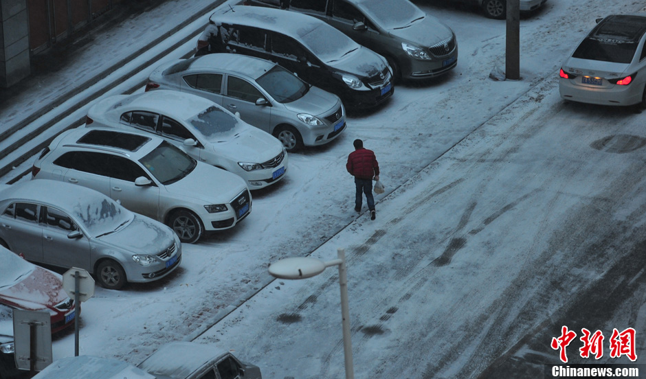 11月18日，行人在沈陽街頭的積雪中穿行。