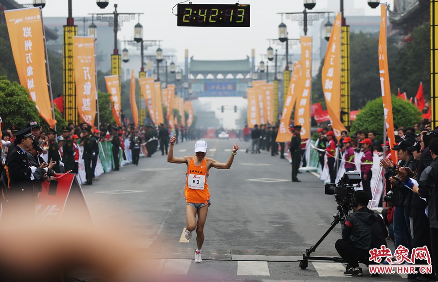 一名選手抵達終點后，高舉雙手慶祝。