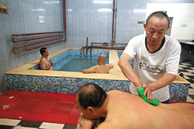 客人在搓澡。近日，百年歷史的鑫園浴池宣布將關(guān)張。新京報(bào)記者