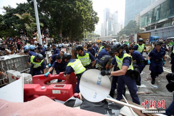 10月14日，警方清除金鐘道障礙物。大批警員在金鐘道現場清拆障礙物。部分警員戴上頭盔將障礙物移走。