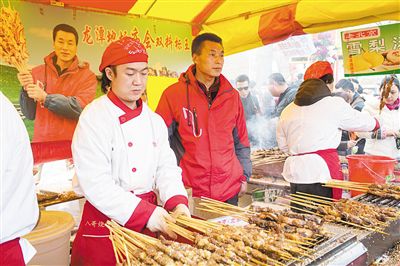 賣羊肉串攤位老板趙山（穿紅衣者）。新京報記者