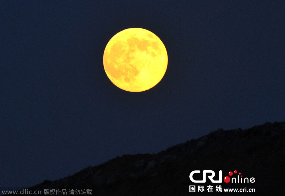 8月10日晚，一輪金燦燦的大月亮在遼寧省大連市東方升起。圖片來源：劉德斌/東方IC