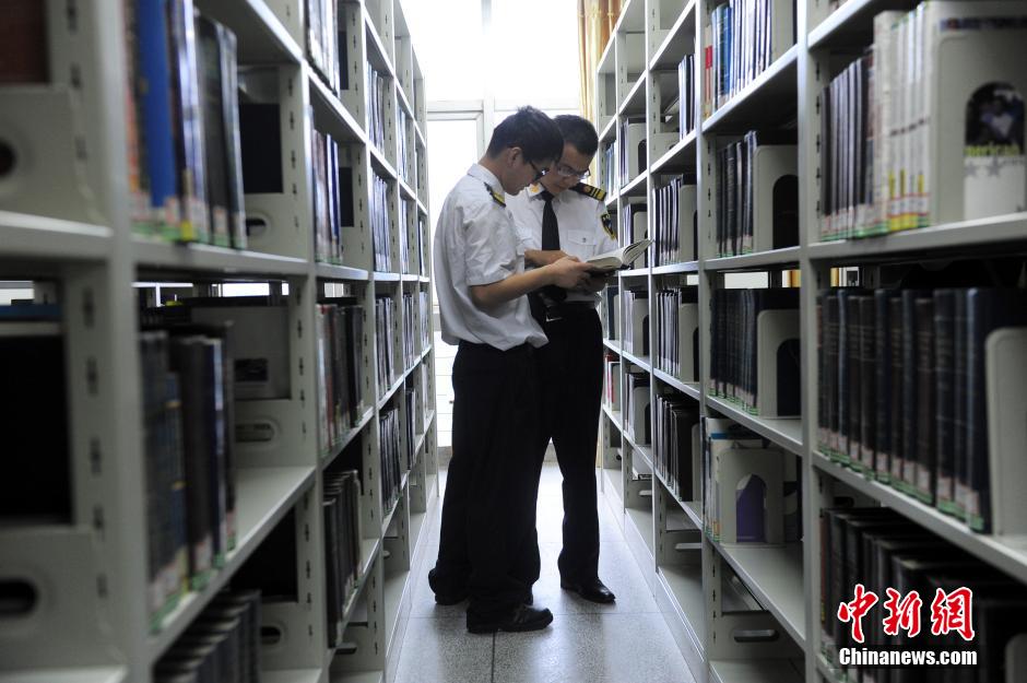 5月8日，武漢輕工大學保安吳濤與江力在圖書館交流學習。中新社發 張暢 攝