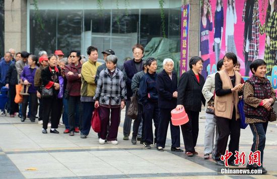 圖為10月28日，在江西九江市一家羊絨皮草服裝服飾博覽會現場，老人們正在頂著寒風排隊等待領取10元代金劵。