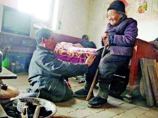 52歲的劉蘭山每天靠爬行照顧90歲的老母親。孫國祥 攝