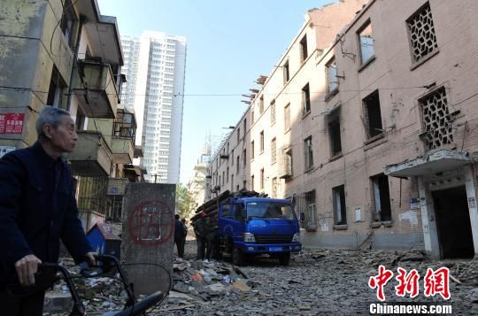 一位花甲老人站在即將拆除的樓房旁，默默地與“蘇聯樓”告別。　翟羽佳　攝